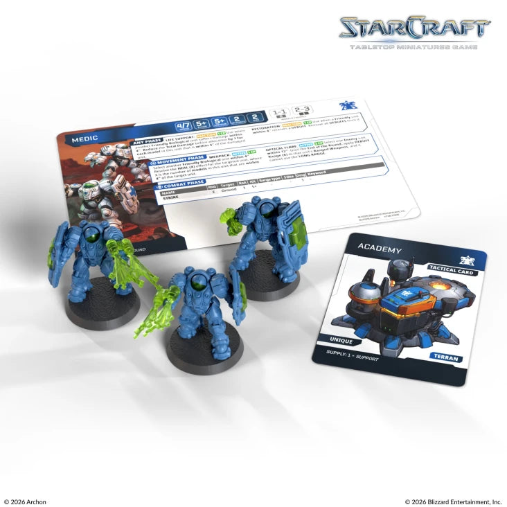 StarCraft TMG: Terran - Medic (PREORDER) - Three blue armored Medic miniatures with green translucent effect on arms, accompanied by two game cards showing stats and.