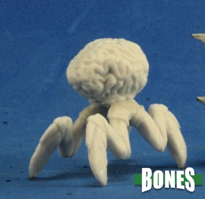 Mind Eater - White resin miniature of a spider-like creature with a large brain for a body against a blue background.
