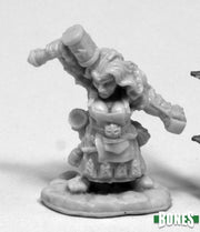 Margara, Dwarf Shaman - Unpainted miniature of a dwarf shaman holding a large staff over her shoulders, wearing layered robes and a decorated belt.