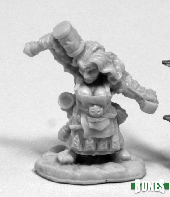 Margara, Dwarf Shaman - Unpainted miniature of a dwarf shaman holding a large staff over her shoulders, wearing layered robes and a decorated belt.