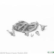 Bone Garden: Creatures - Unassembled gray resin miniature of a curled fantasy creature skeleton with separate skull and bone parts.