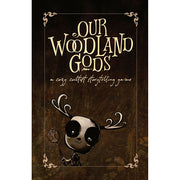 Our Woodland Gods RPG: A Cozy Cultist Storytelling Game (PREORDER) - Dark brown game box with ornate gold lettering saying Our Woodland Gods and a cute black-and-white deer-like creature.