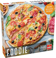 Foodie Pizza Pizza 300 Piece Puzzle - 300-piece puzzle featuring a colorful, sliced pizza with toppings like pepperoni, olives, basil, and tomatoes on a rustic.