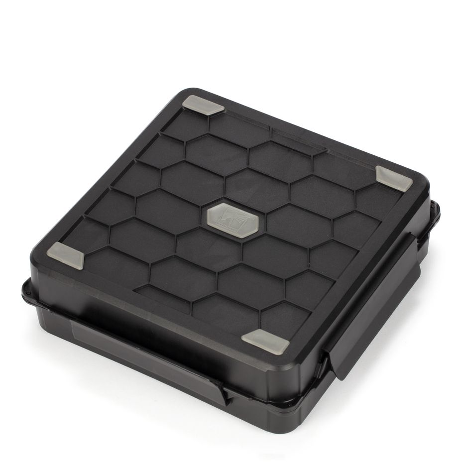 Strormvault Skirmish Figure Case - Black square compact figure case with hexagonal pattern and metallic corner accents.