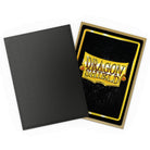 Dragon Shield Standard DUAL Matte Sleeves: Matte Black & Gold (PREORDER) - Matte black card sleeve next to a gold-bordered Dragon Shield card sleeve with embossed logo and black background.