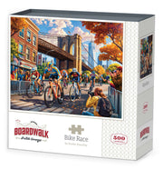 Boardwalk 500 Piece Puzzle: Bike Race - 500-piece jigsaw puzzle featuring colorful bike race scene near Brooklyn Bridge with autumn trees and city buildings.