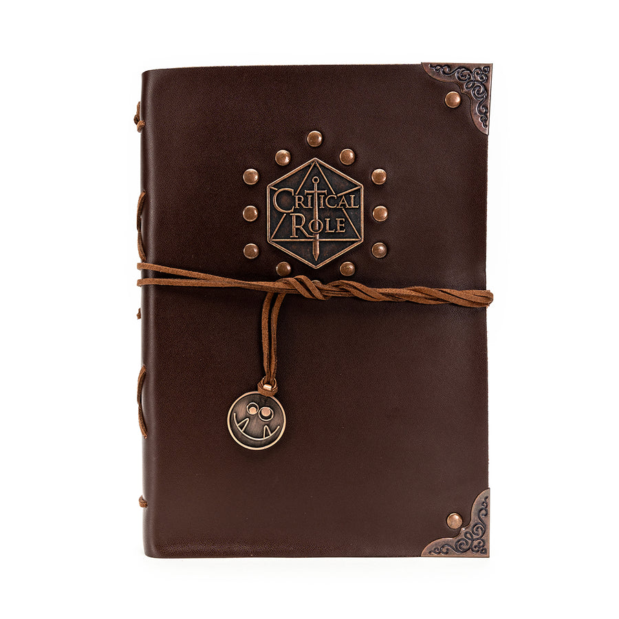 Critical Role Sketchbook - Dark brown leather sketchbook with embossed Critical Role logo, decorative metal corners, and leather tie with metal charm.