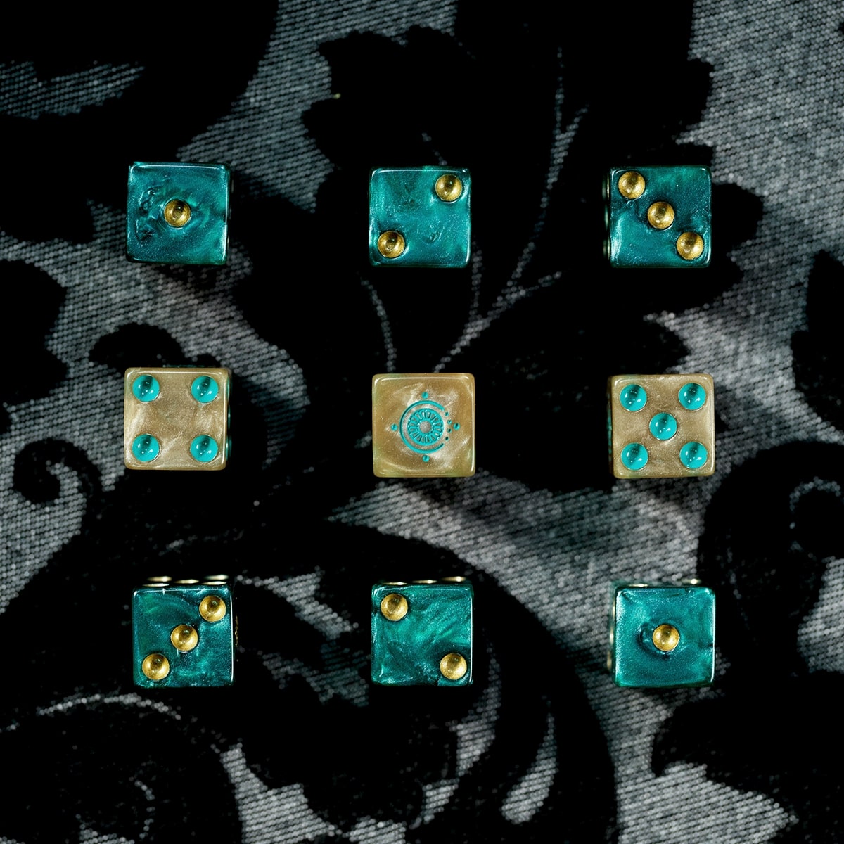 Candela Obscura Official Dice Set - Set of nine six-sided dice in teal with gold pips, arranged in a 3x3 grid on black velvet background.