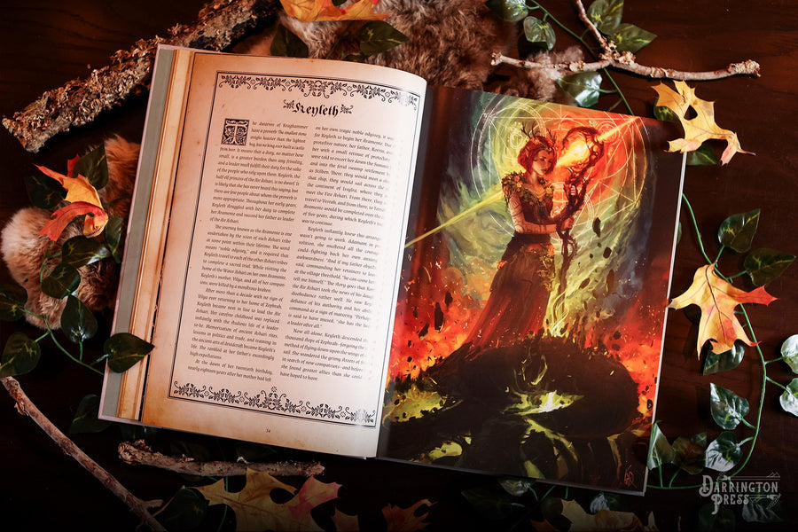 The Chronicles of Exandria Vol I: The Tale of Vox Machina - Open hardcover book showing ornate text layout beside book cover featuring fiery warrior woman with raised sword amidst.