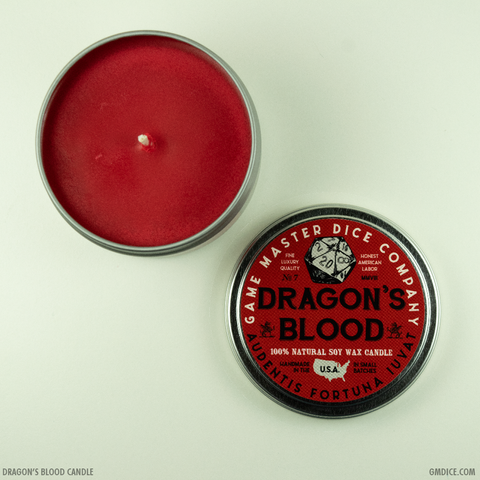 Dragon's Blood Gaming Candle - Red wax candle in a round silver tin with a black and red lid labeled "Dragon’s Blood" and "Game Master Dice Company".