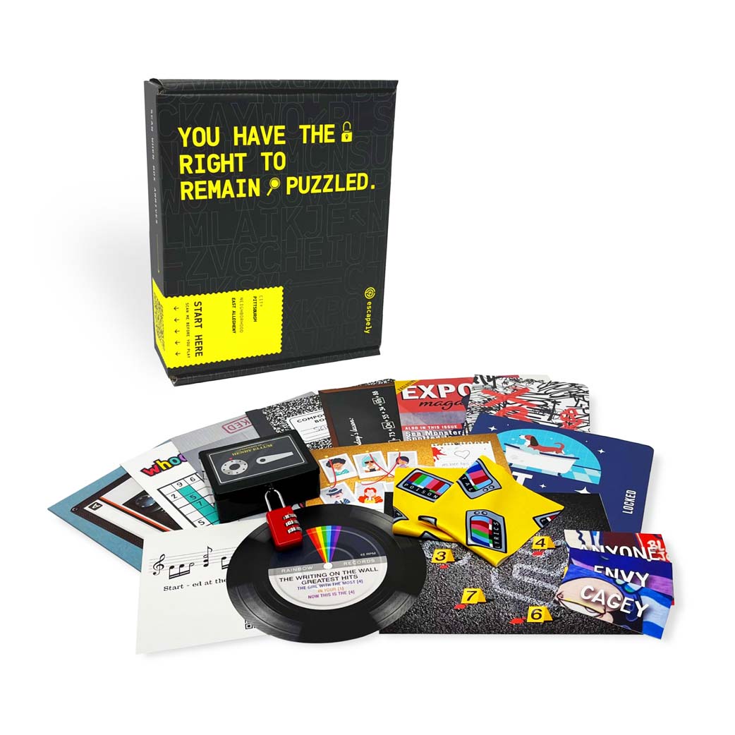 Escape the City Whodunnit: Salt Lake City - Black and yellow box labeled "You Have the Right to Remain Puzzled" with assorted colorful game cards, a mini vinyl record,.