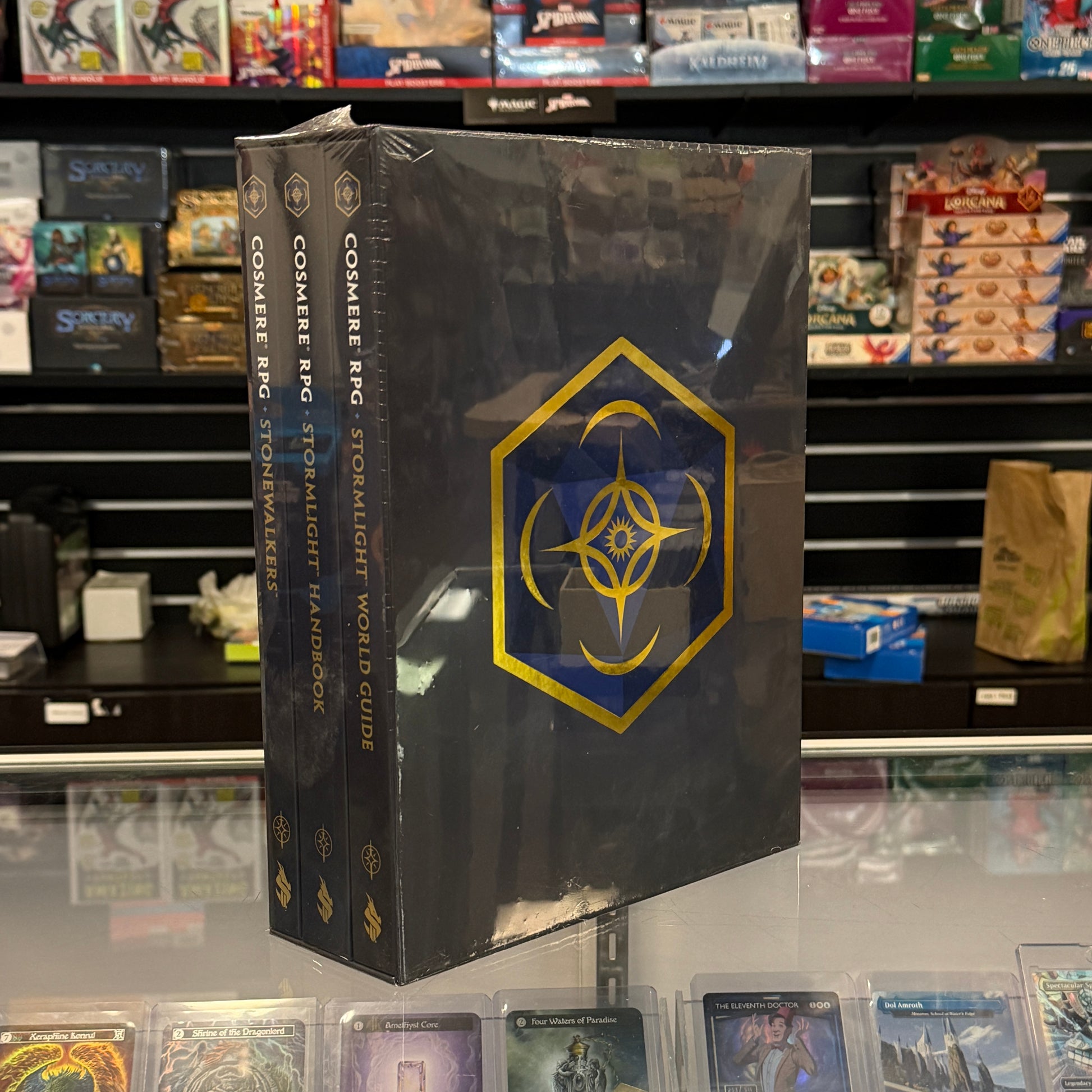 Cosmere RPG Kickstarter Set Case - Black hardcover set with gold geometric emblem and intricate designs on spine and cover, standing upright.