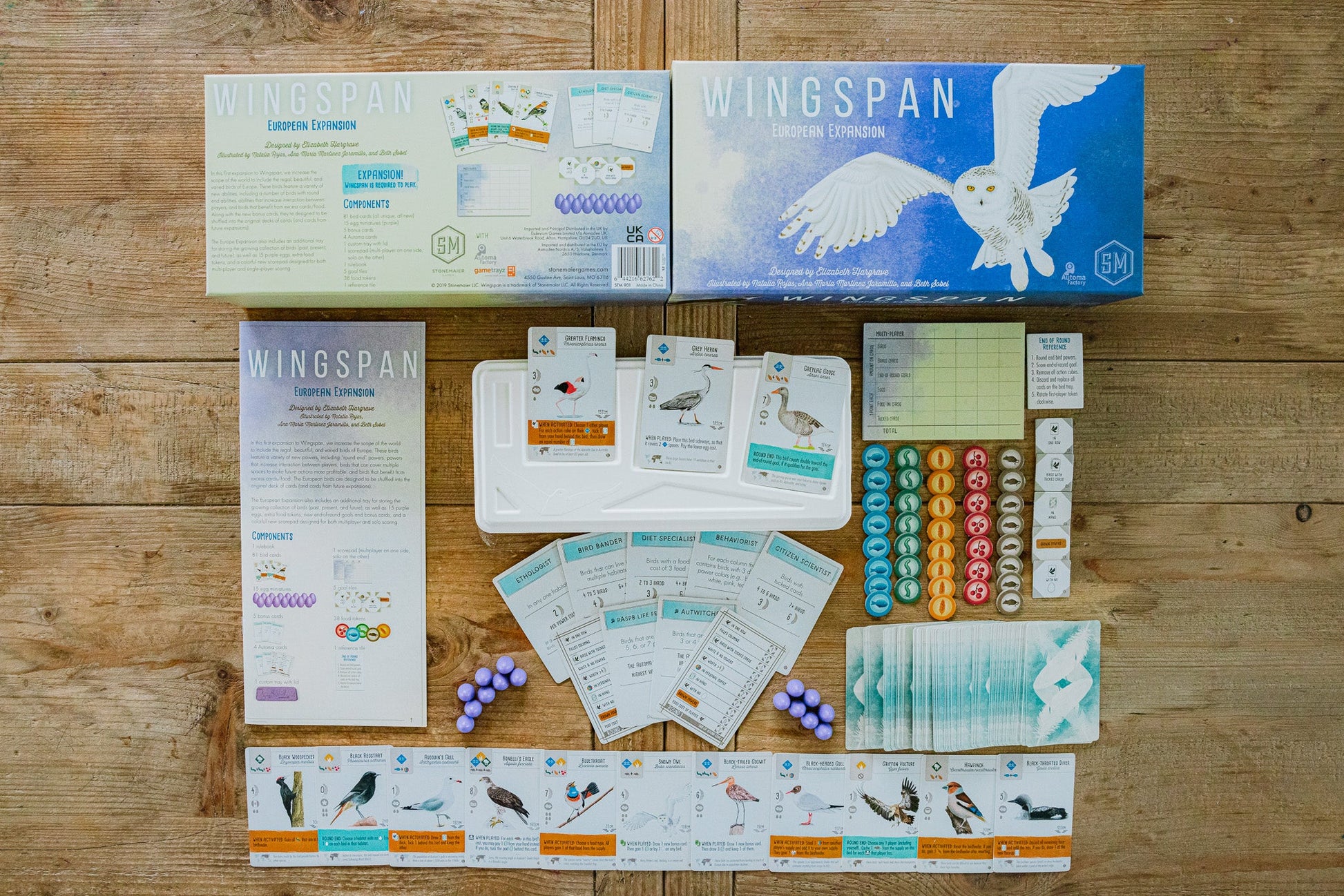 Wingspan: European Expansion - Board game box with a white owl illustration, rulebooks, player boards, bird cards, dice, tokens, and score sheets arranged.