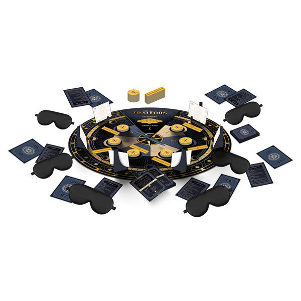 The Traitors - Round black and gold game board with playing cards, black sleep masks, wooden tokens, and yellow dice arranged around it.