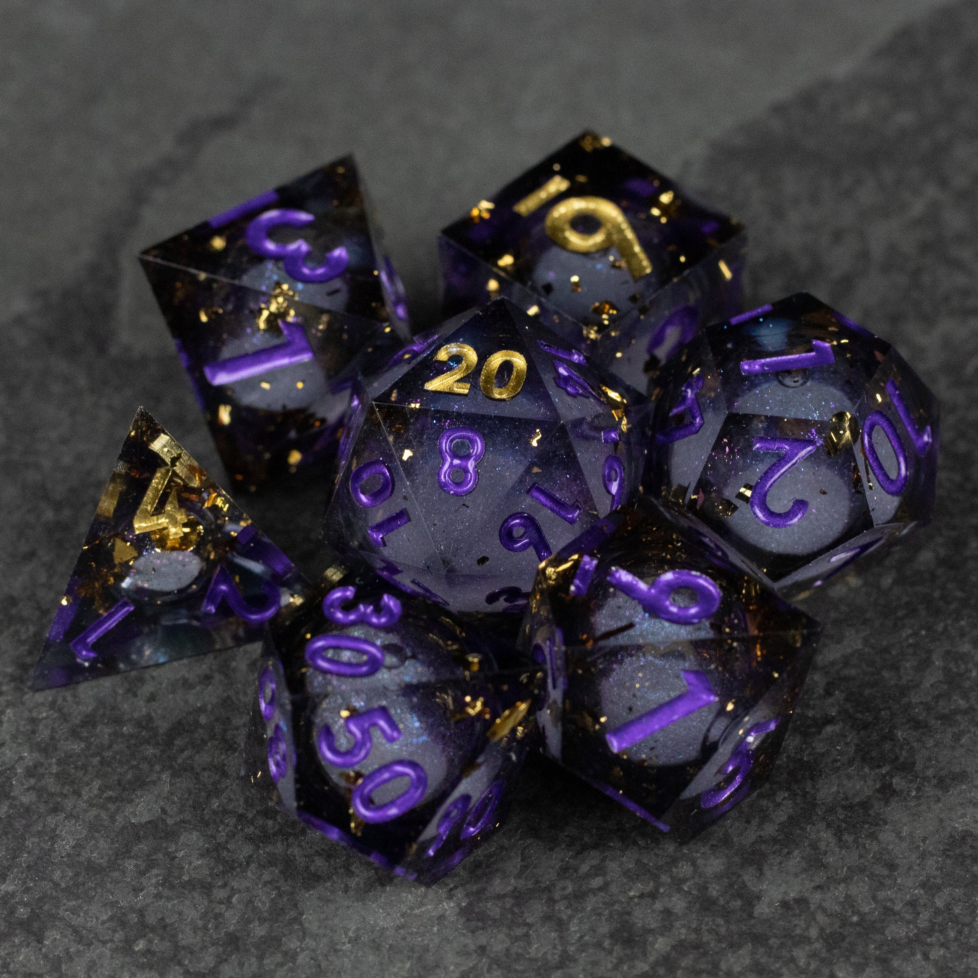 Witching Hour Liquid Core Dice - Set of seven sharp-edged translucent black dice with purple numbers and gold liquid core accents.