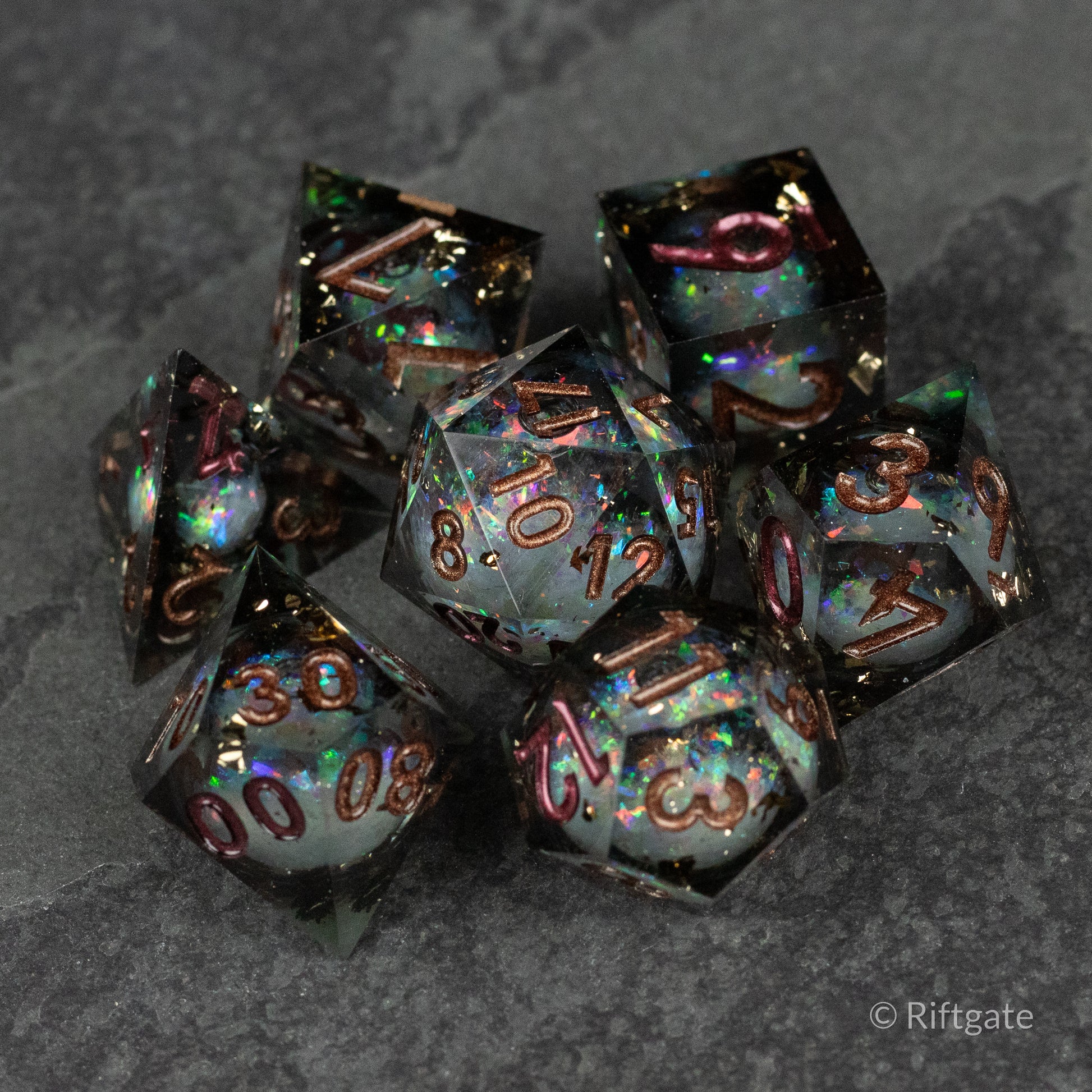 Wild Magic Liquid Core Dice Set - Set of seven sharp-edged polyhedral dice with dark translucent bodies and swirling iridescent liquid cores, featuring.
