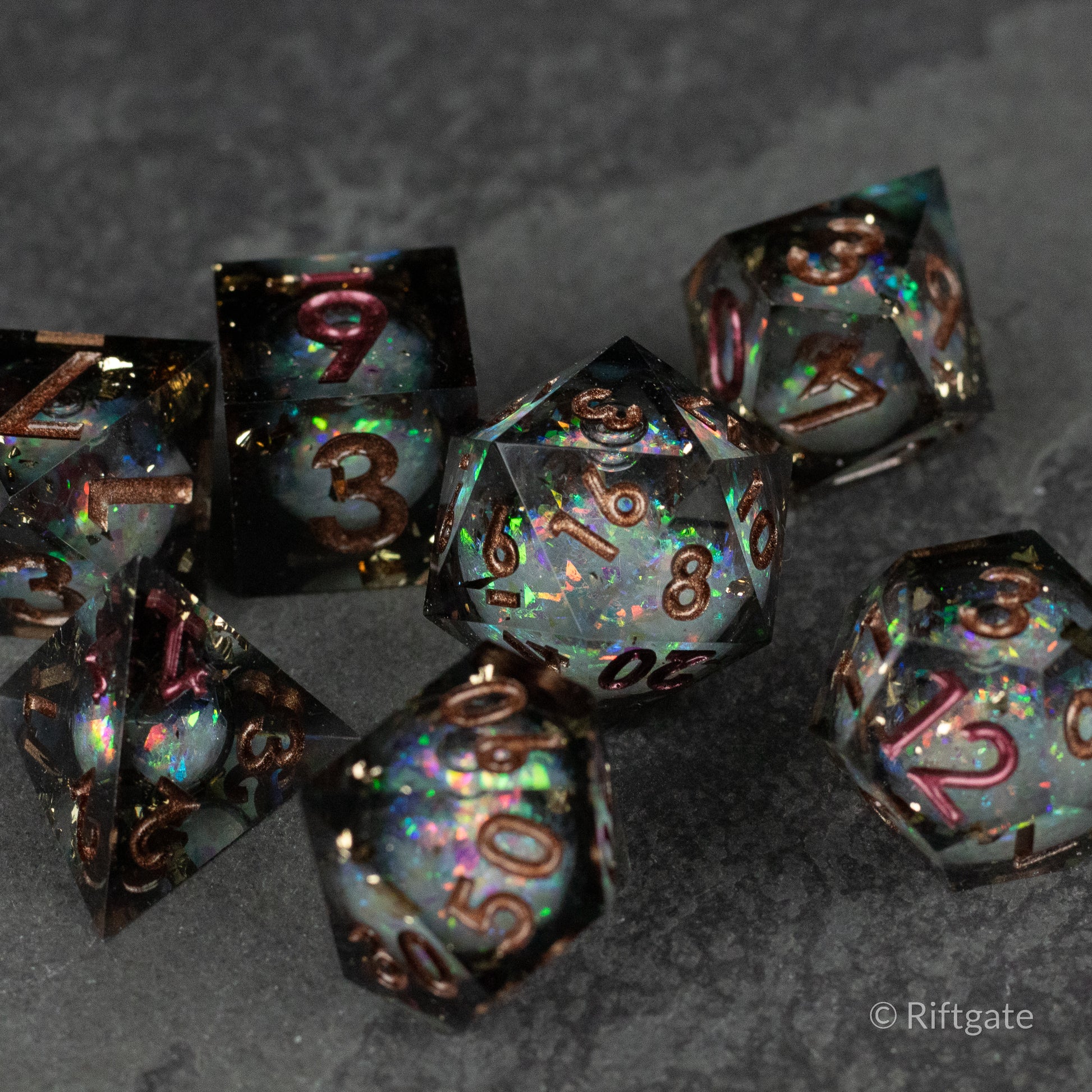 Wild Magic Liquid Core Dice Set - Set of seven multifaceted sharp-edged dice with swirling blue, purple, and gold liquid core designs and metallic numbers.