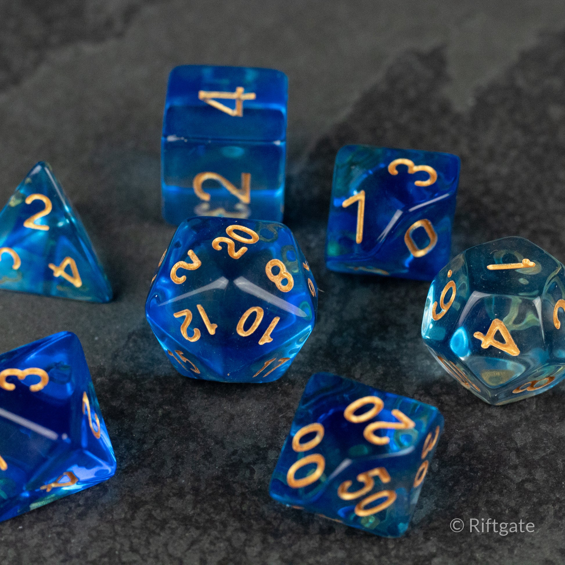 Ethereal Mist Dice Set - Translucent blue polyhedral dice set with gold numbering, including d4, d6, d8, d10, d12, and d20 shapes.