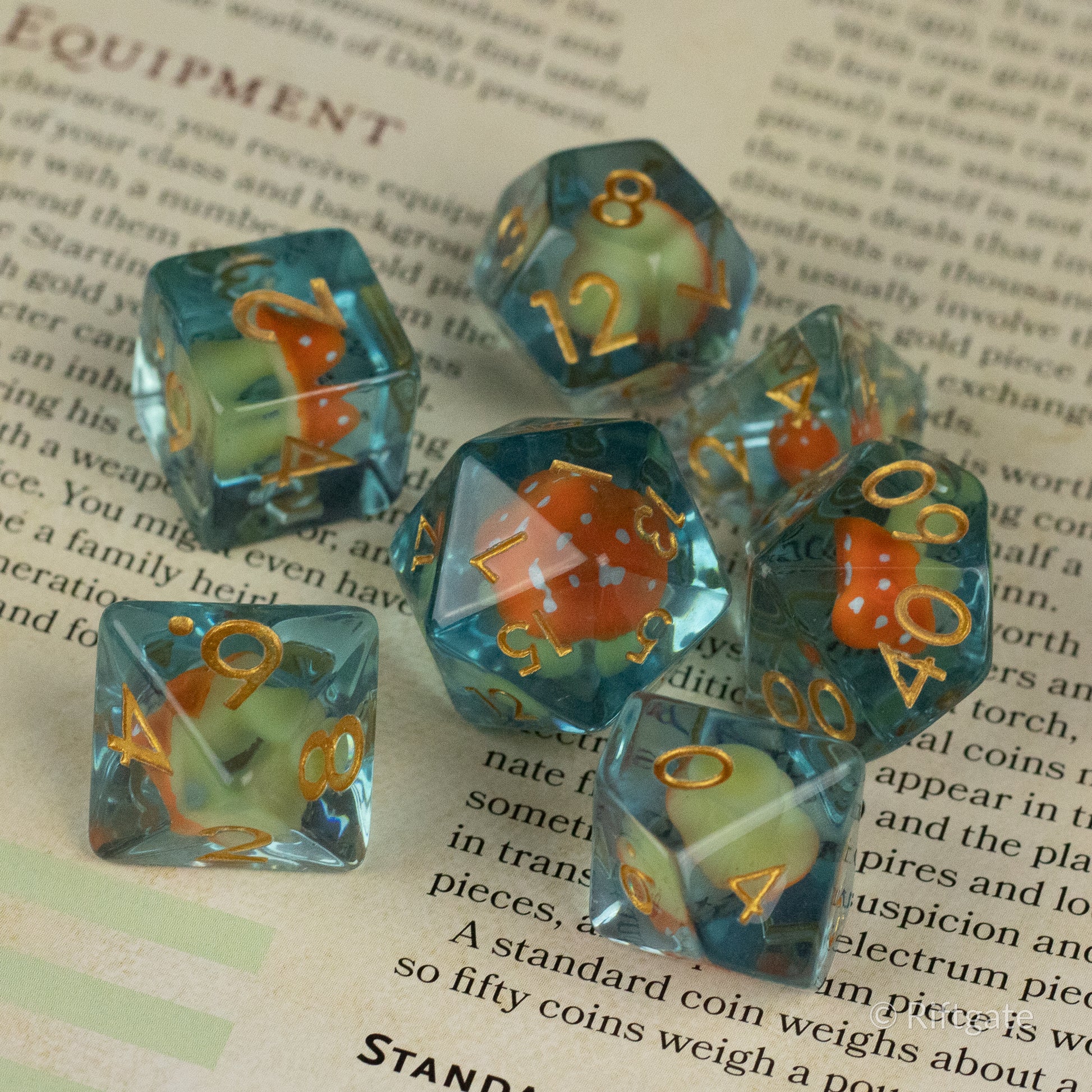 Orange + Blue Resin Mushroom Dice Set - Seven blue translucent resin dice with embedded orange mushroom inclusions, featuring gold numbers.