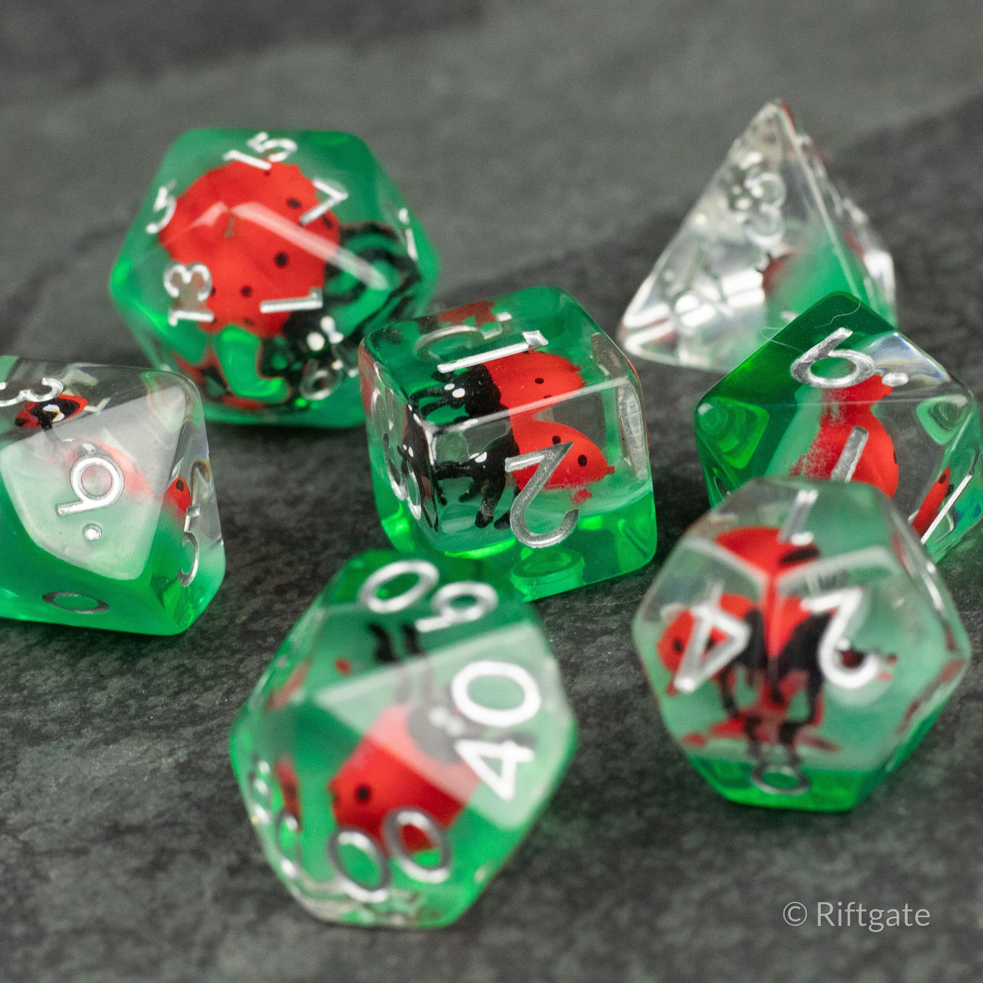 Ladybug Dice Set - Type 2 - Set of translucent green and clear polyhedral dice with red and black ladybug designs and white numbering.