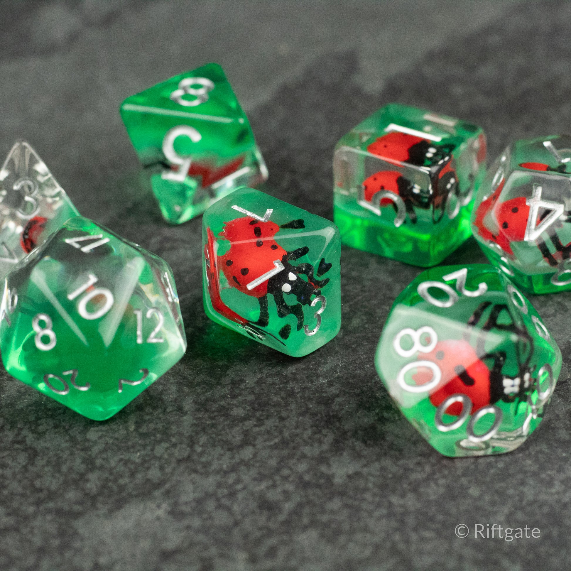 Ladybug Dice Set - Type 2 - Clear and green translucent polyhedral dice with embedded red and black ladybug figures, white numbering.