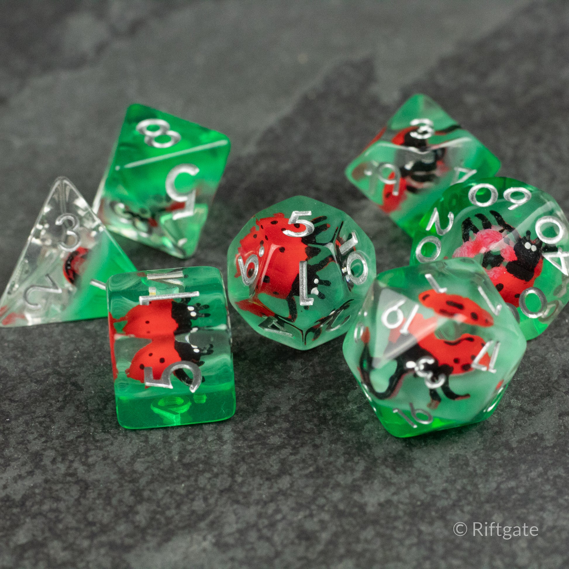 Ladybug Dice Set - Type 2 - Transparent green and clear polyhedral dice set with red and black ladybug inclusions and white numbering.