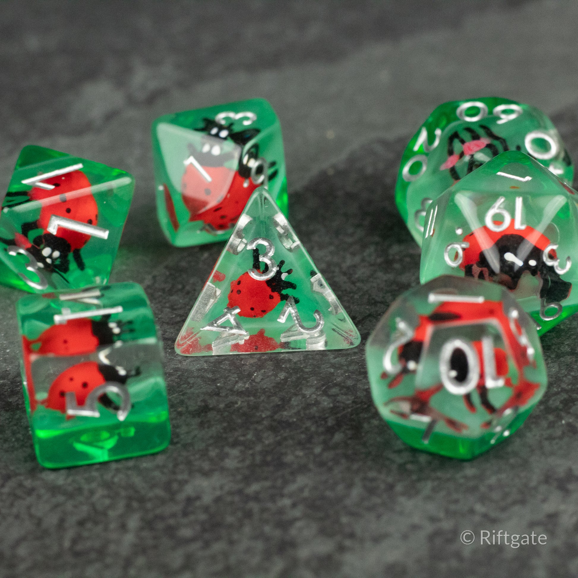 Ladybug Dice Set - Type 2 - Green translucent polyhedral dice set with red and black ladybug designs, including d4, d6, d8, d10, d12, and d20.