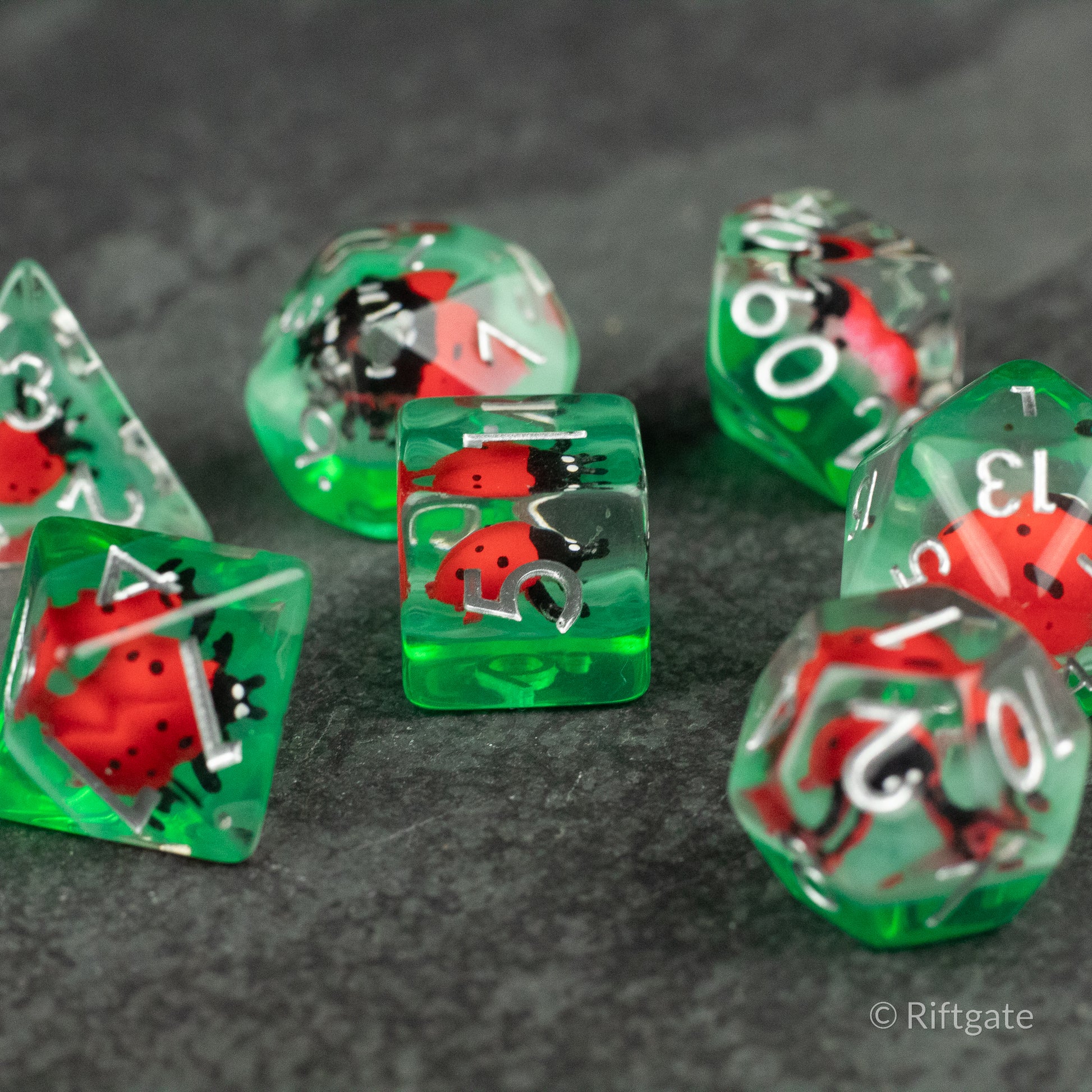 Ladybug Dice Set - Type 2 - Green translucent polyhedral dice set with embedded red and black ladybugs and white numbering.