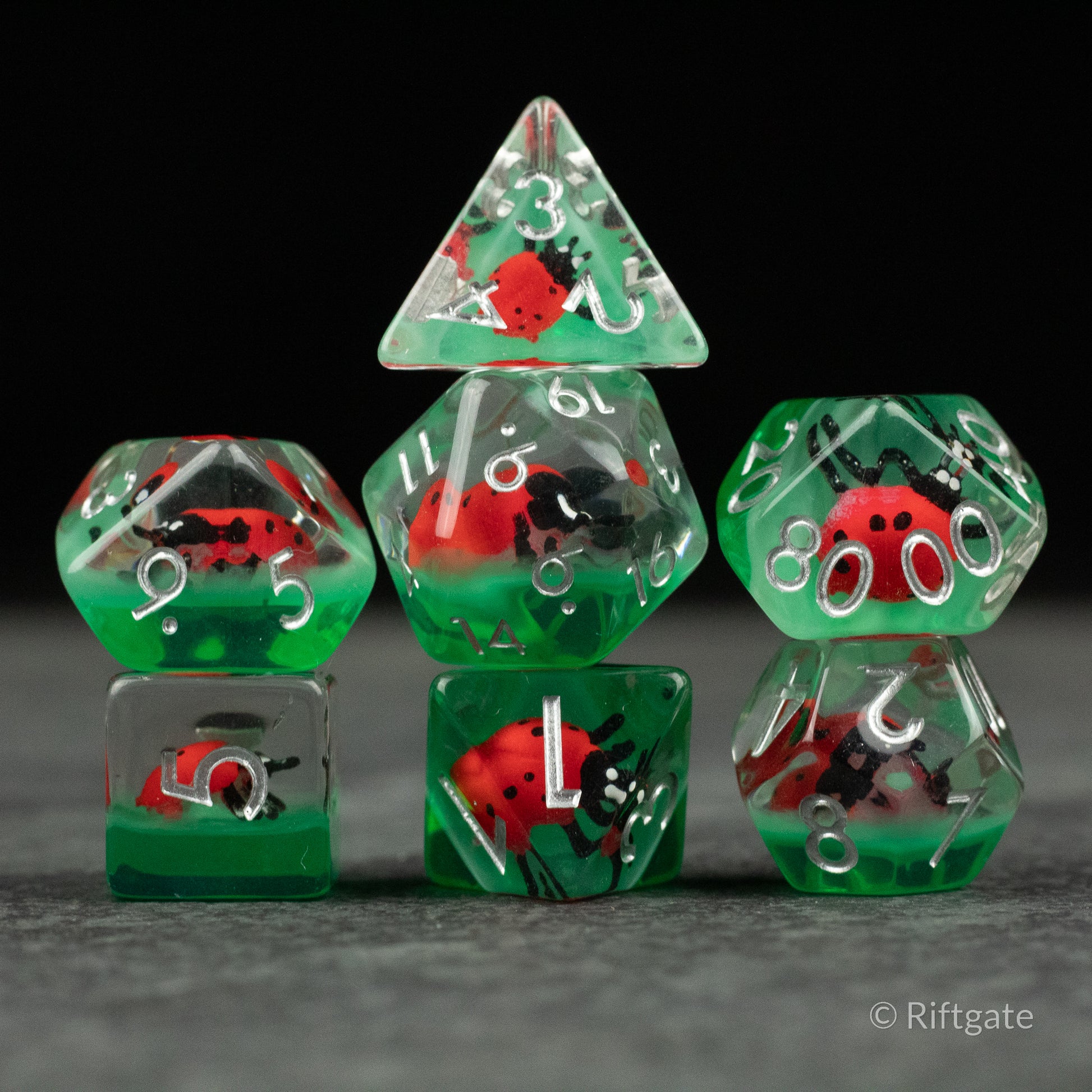Ladybug Dice Set - Type 2 - Transparent green polyhedral dice set with red and black ladybug inclusions and white numbers.