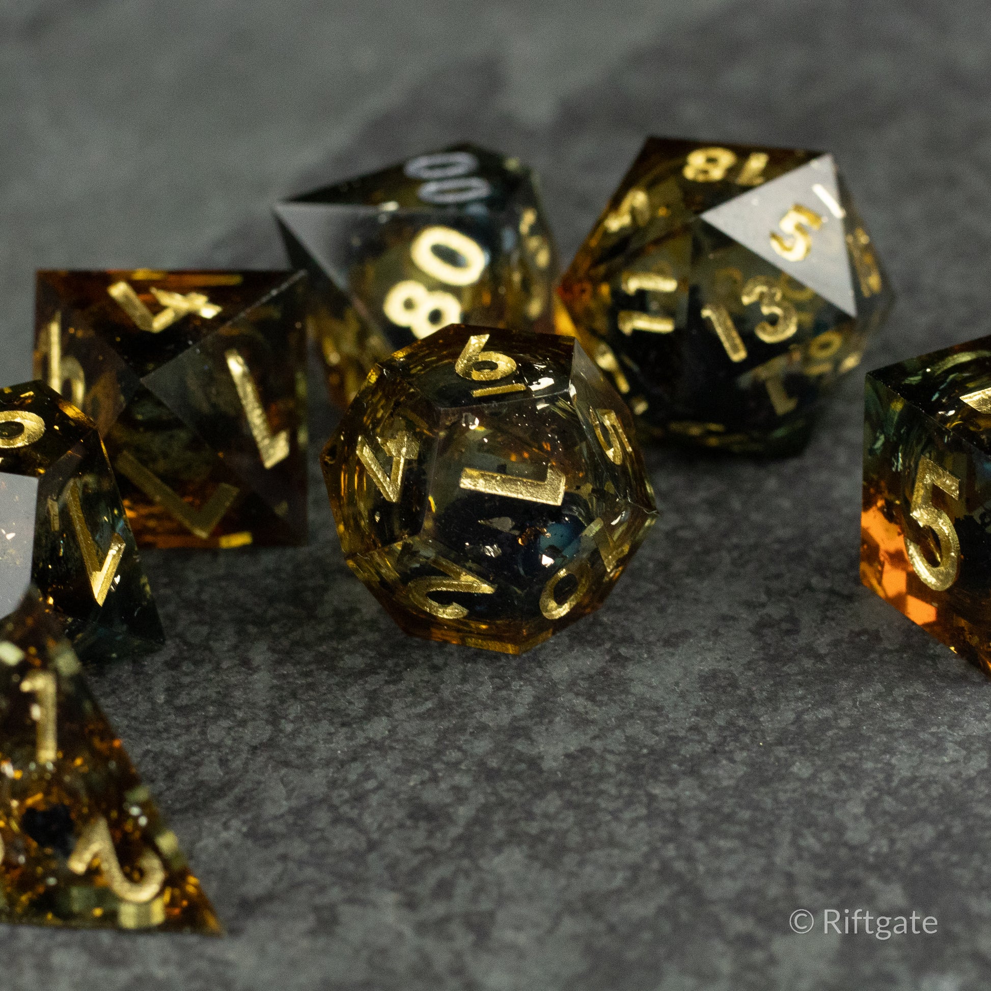 Ambershadow Dice Set - Set of translucent amber and black polyhedral dice with gold and white numbering, glossy finish.