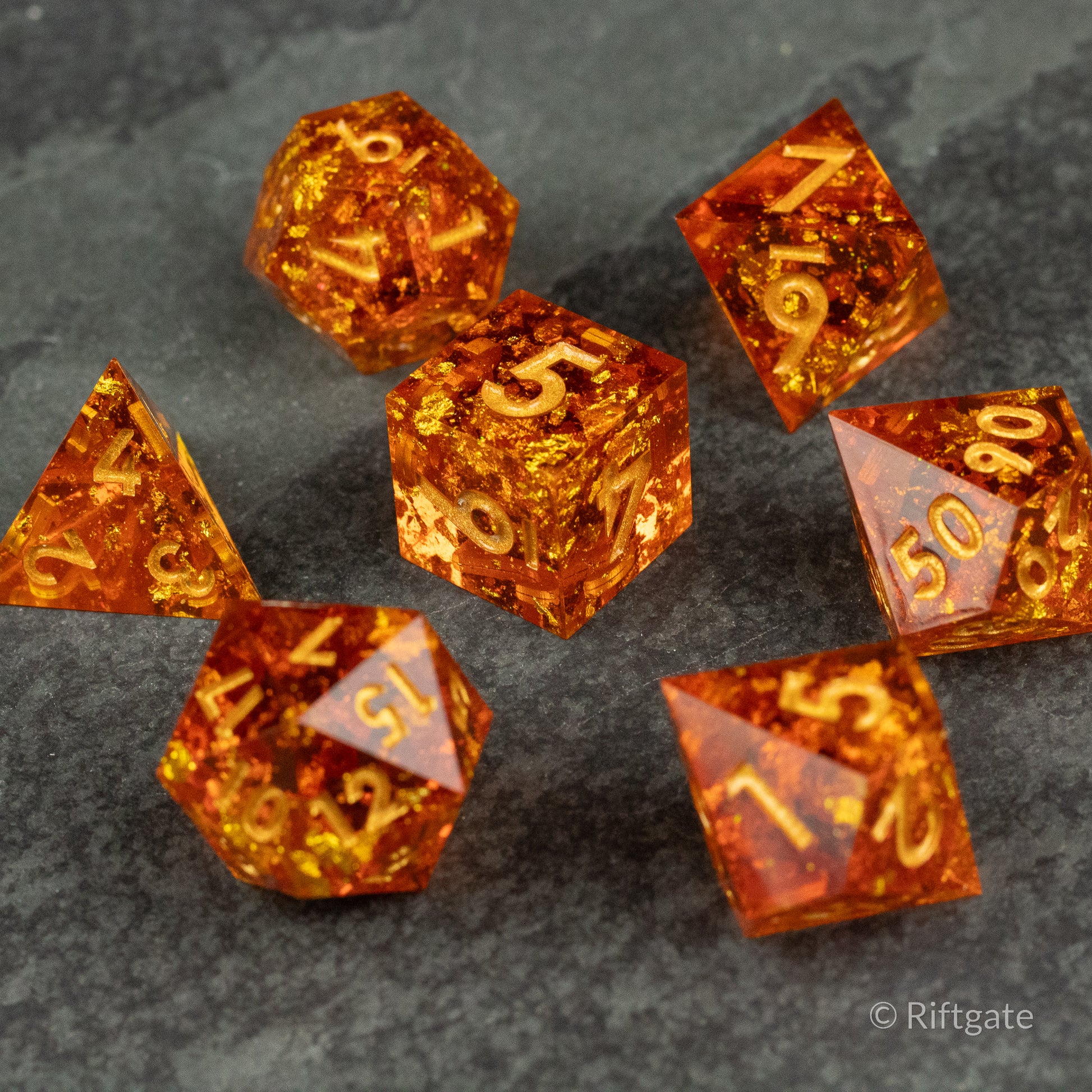 Sunforged Dice Set - Seven translucent orange polyhedral dice with gold flecks and sharp edges on a dark textured surface.