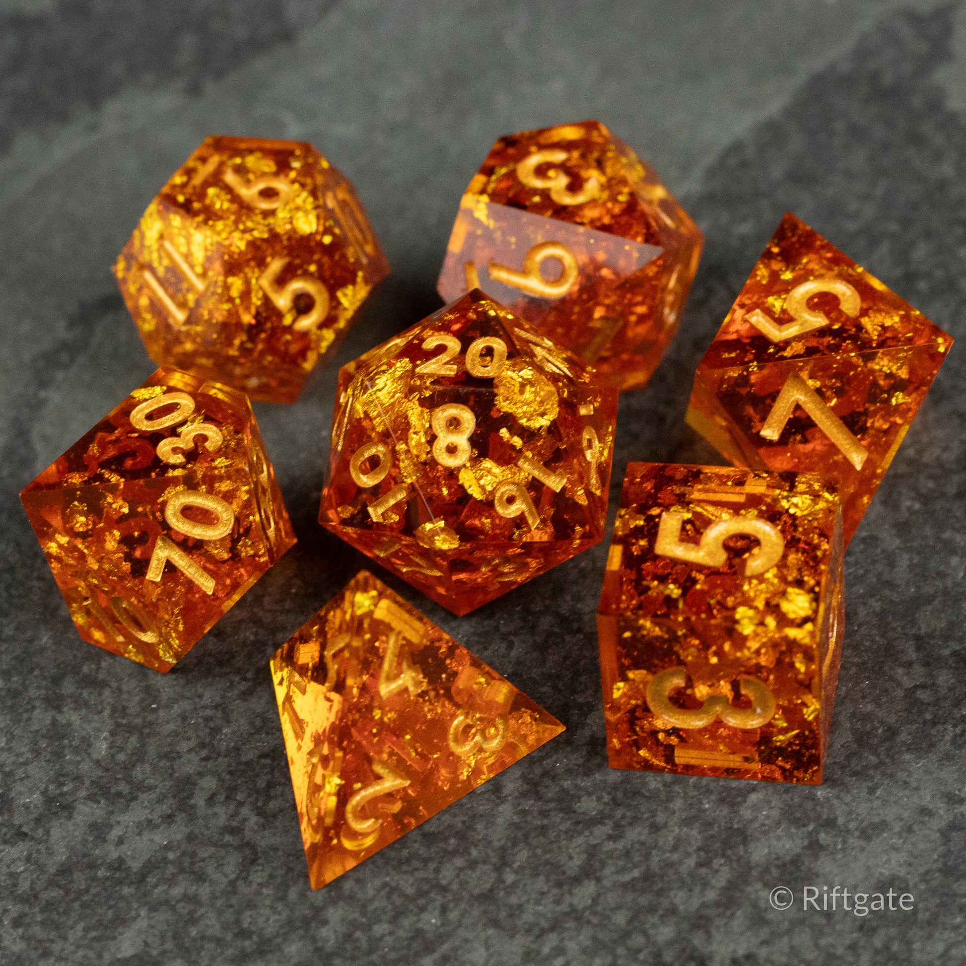 Sunforged Dice Set - Seven orange translucent polyhedral dice with gold numbers and sharp edges on a dark surface.