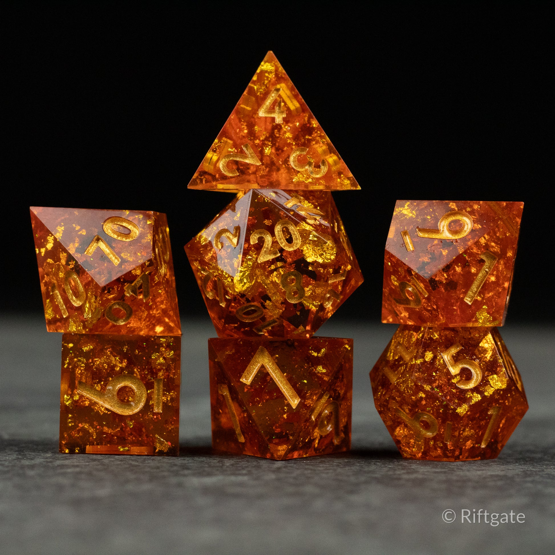 Sunforged Dice Set - Seven-piece translucent amber dice set with sharp edges and gold numbering, featuring varied polyhedral shapes.