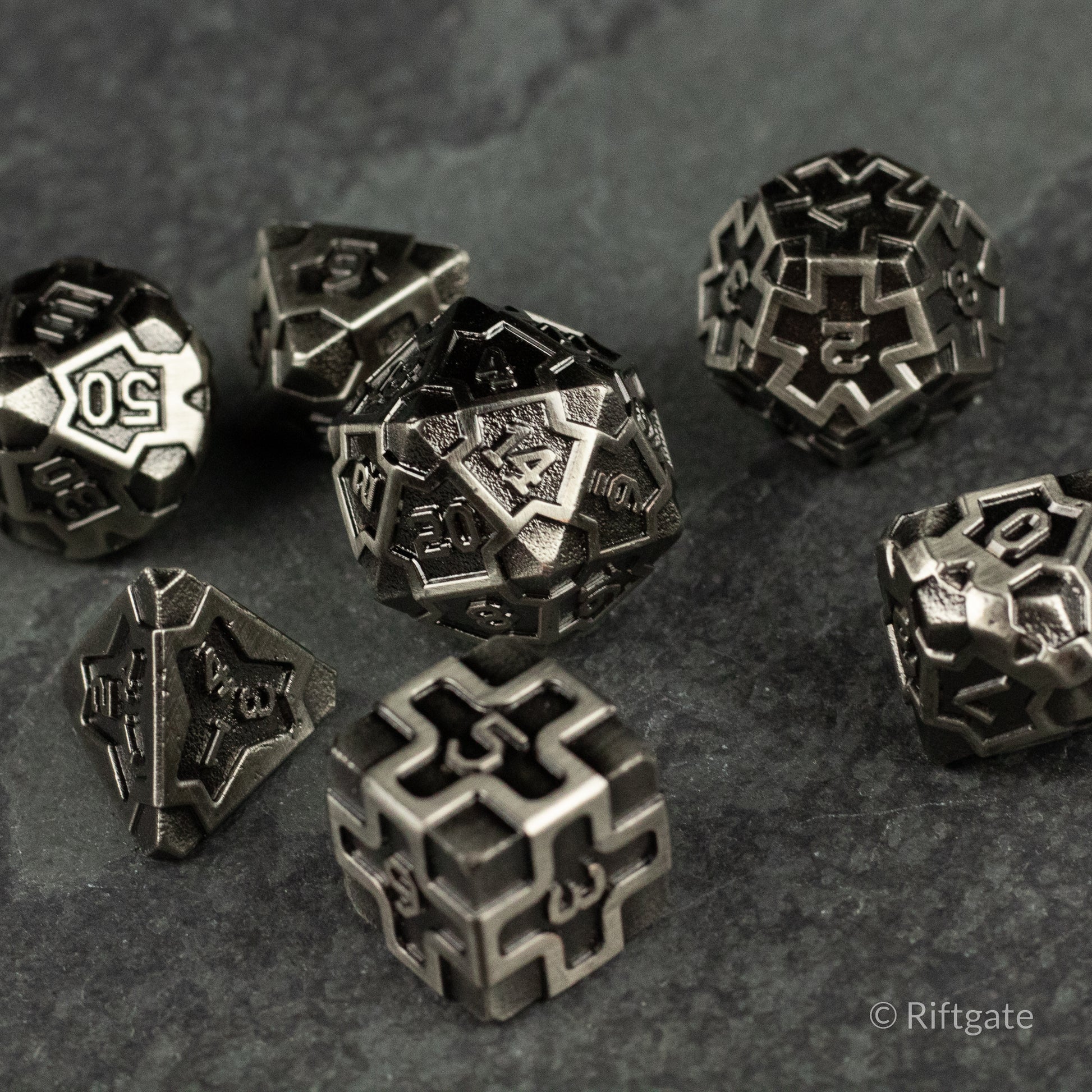 Iron Crusader - Set of metallic polyhedral dice with intricate, industrial patterns and angular engravings, dark silver finish.