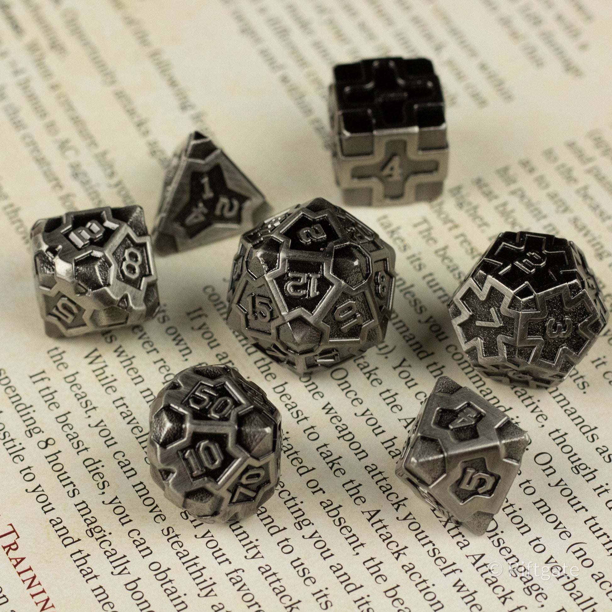 Iron Crusader - Set of seven metallic polyhedral dice with intricate engraved numbers and dark recessed detailing, including d4, d6, d8,.