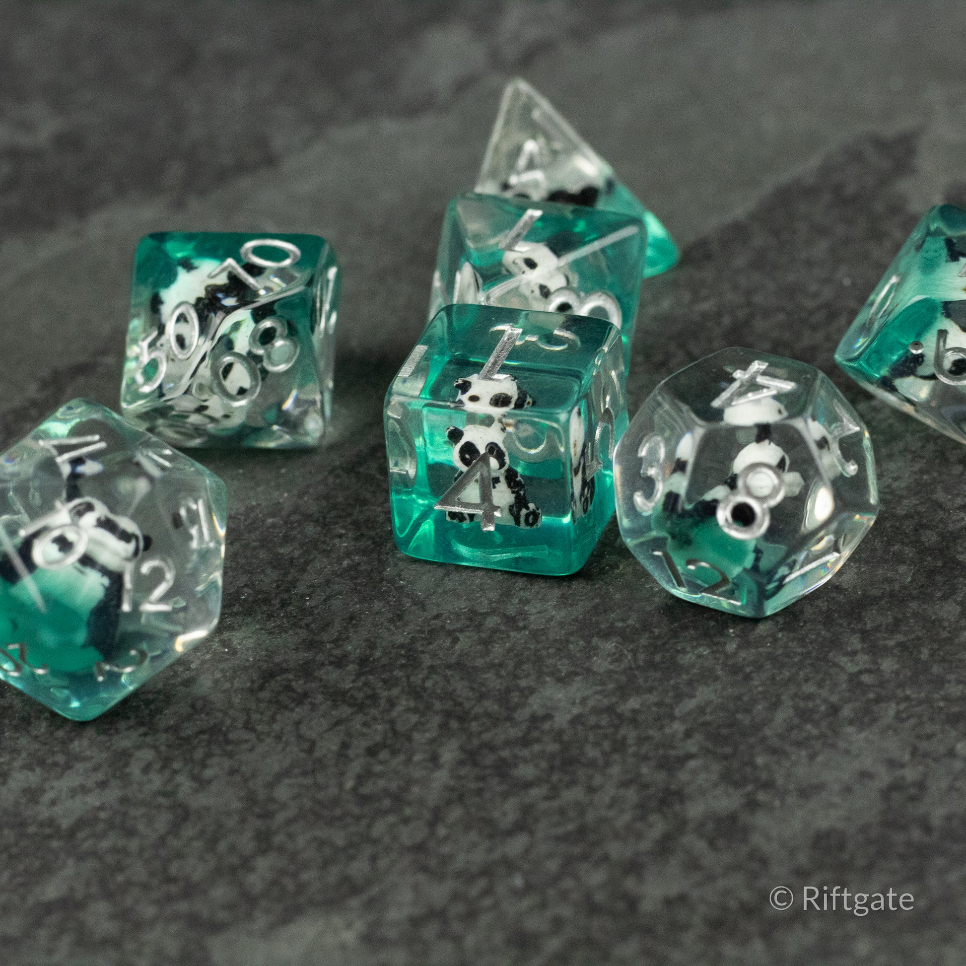 Panda Dice Set - Transparent teal polyhedral dice set with white panda face icons replacing some numbers.