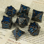 Gray Empyrean Artifact Dice Set - Set of seven gray metal dice with intricate blue enamel designs and numbers, various polyhedral shapes.