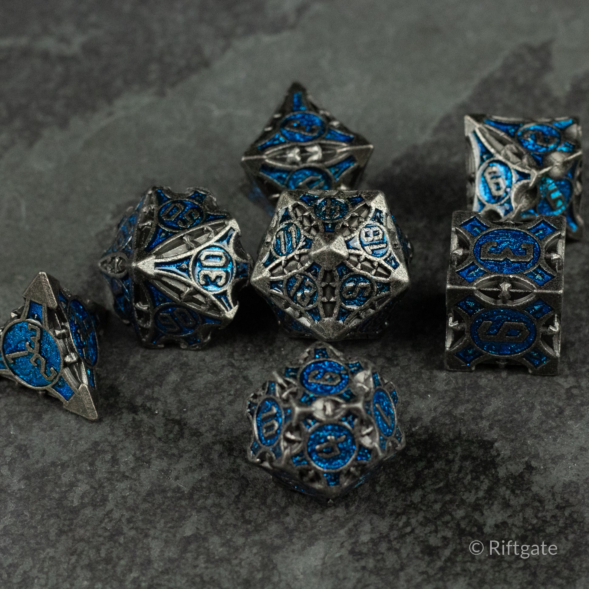 Gray Empyrean Artifact Dice Set - Metallic gray polyhedral dice set with intricate blue engravings and ornate designs.
