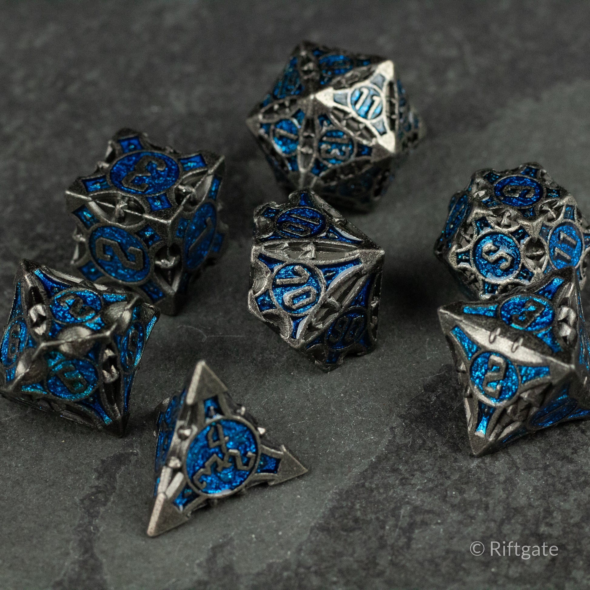 Gray Empyrean Artifact Dice Set - Gray metal polyhedral dice set with intricate blue inlays and engraved symbols.