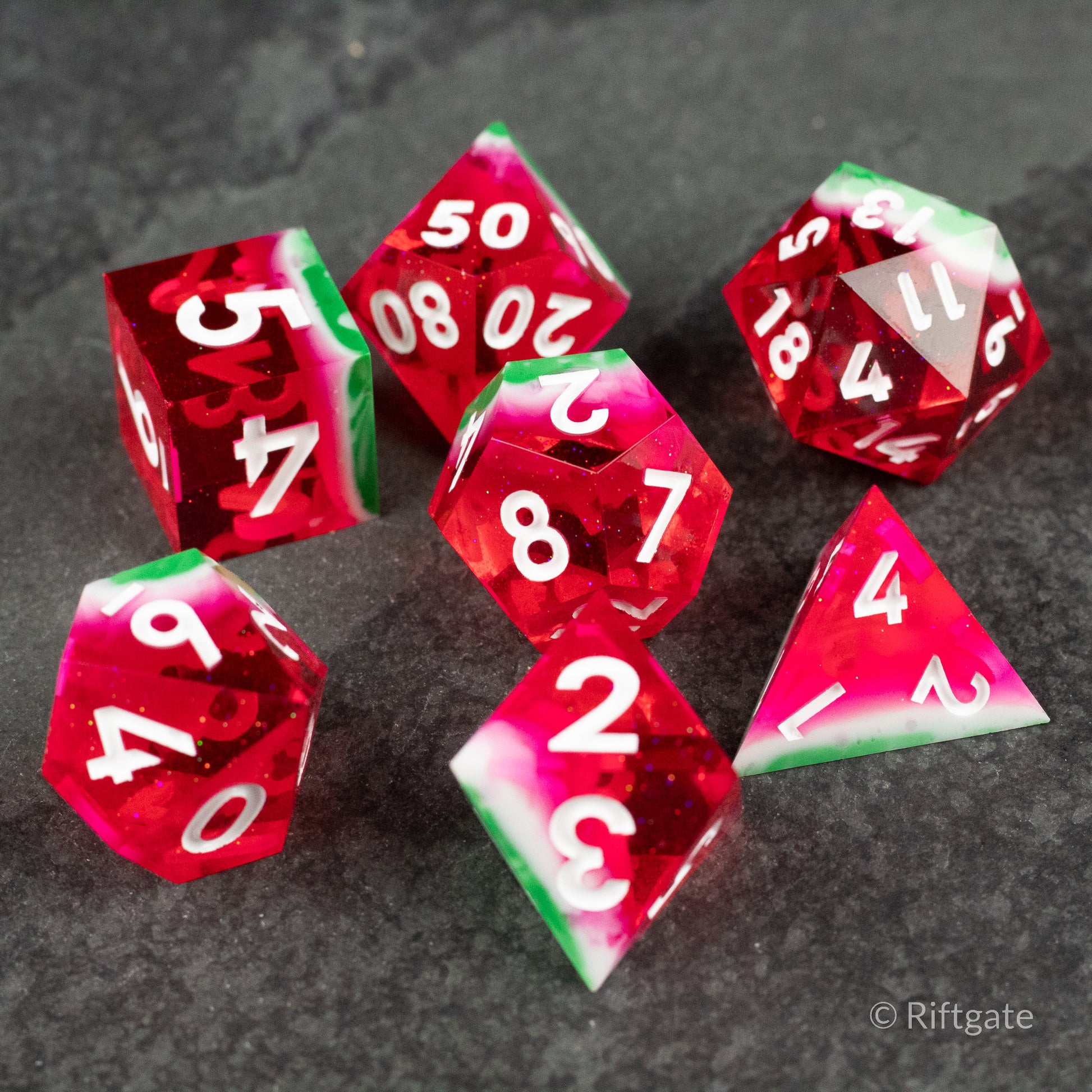Watermelon Sharp Edge Dice - Set of six sharp-edged polyhedral dice with watermelon-inspired red, green, and white colors and white numbering.