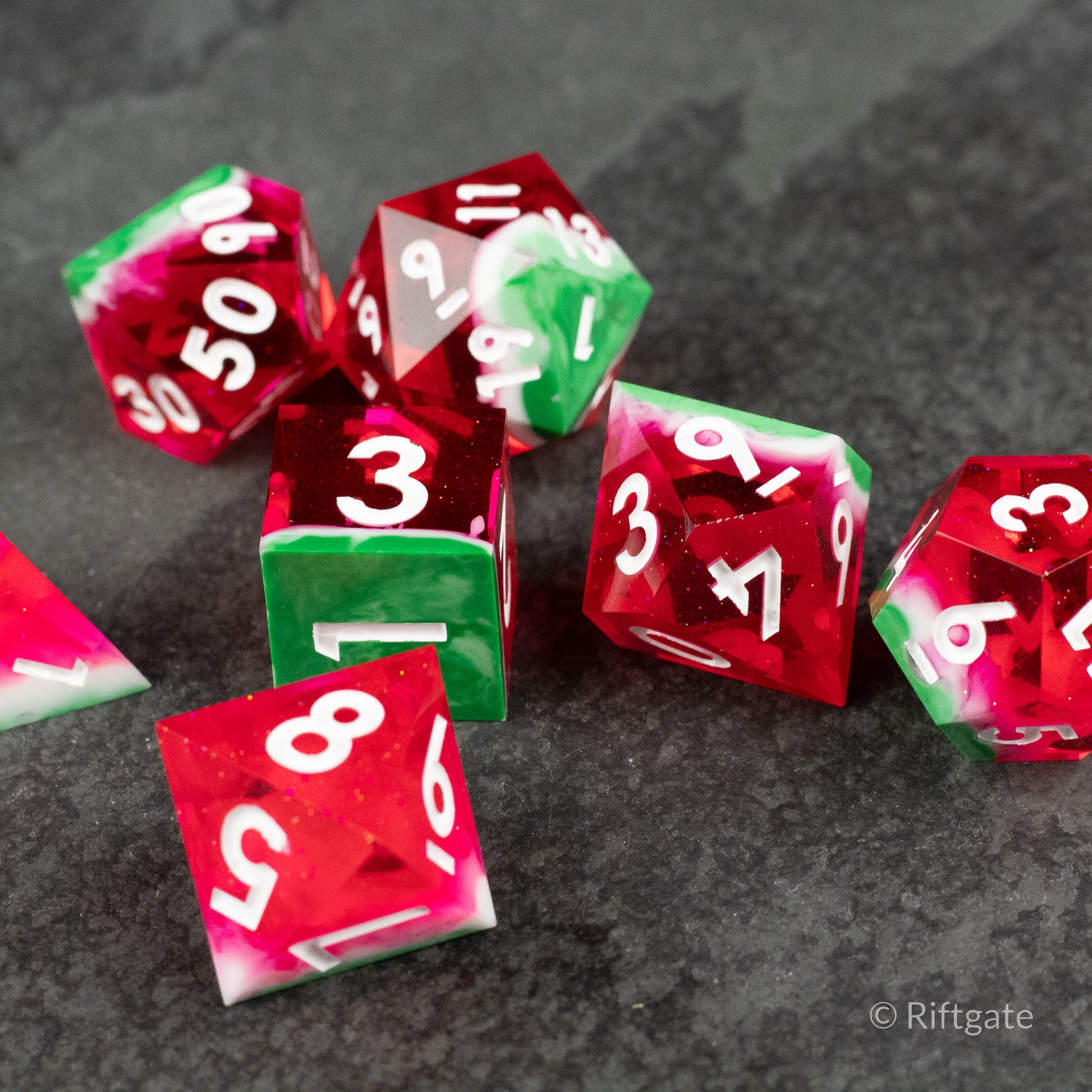 Watermelon Sharp Edge Dice - Set of sharp-edged polyhedral dice with red, green, and white watermelon-inspired translucent colors and white numbering.
