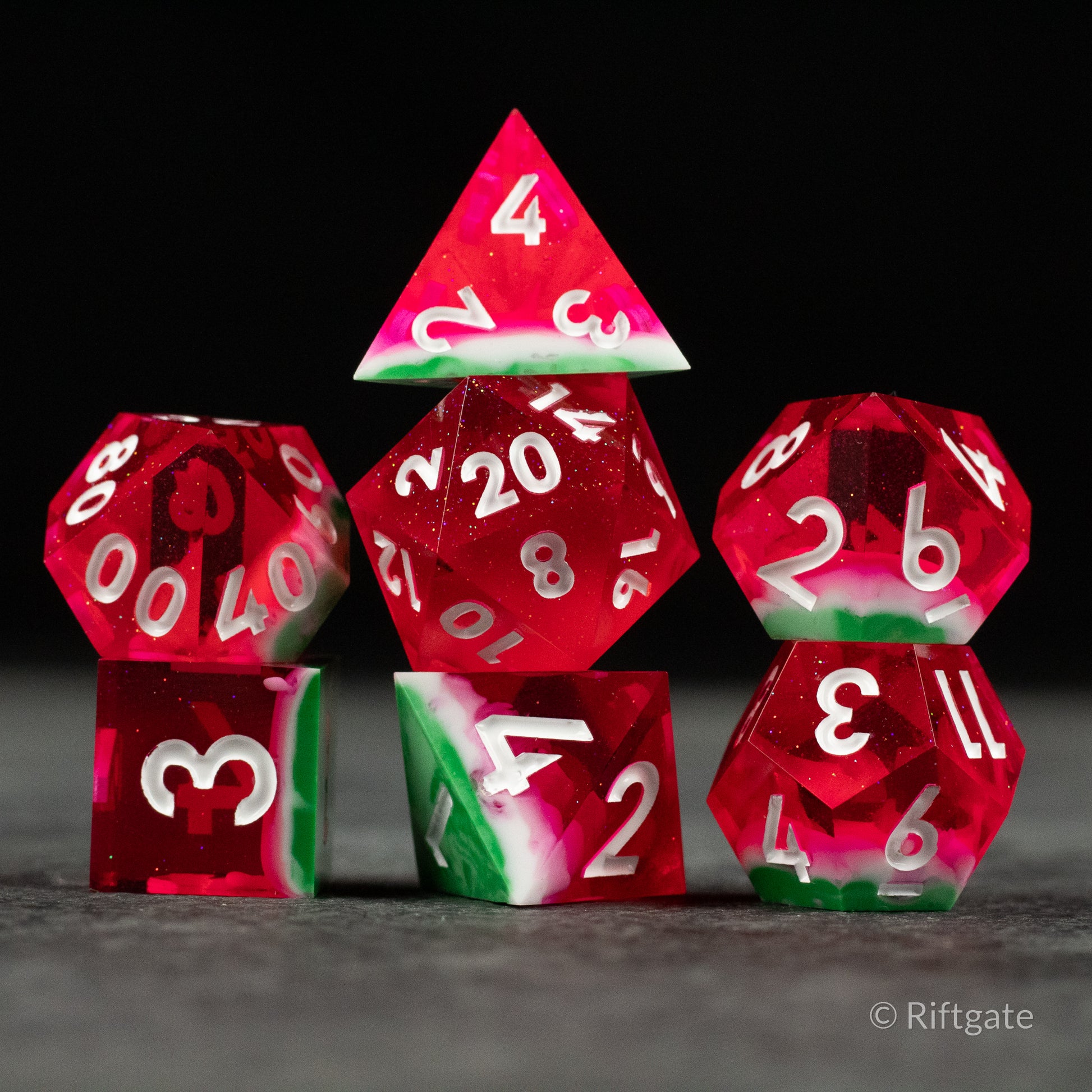 Watermelon Sharp Edge Dice - Set of seven translucent red sharp-edged dice with white numbers and green-white accents resembling watermelon colors.