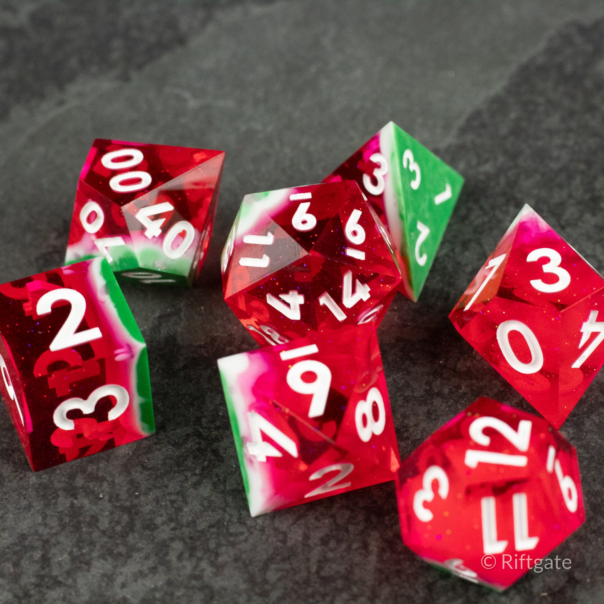 Watermelon Sharp Edge Dice - Set of red and green sharp-edged polyhedral dice with white numbers, featuring a watermelon-inspired design.