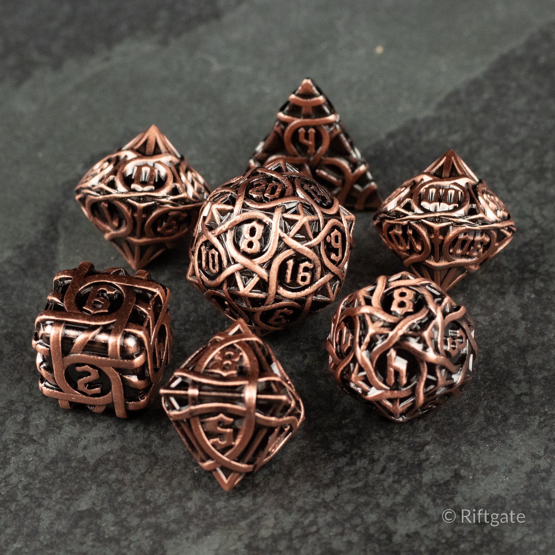 Runeweave Metal Dice Set - Copper-toned metal RPG dice set with intricate rune engravings and a shiny polished finish.