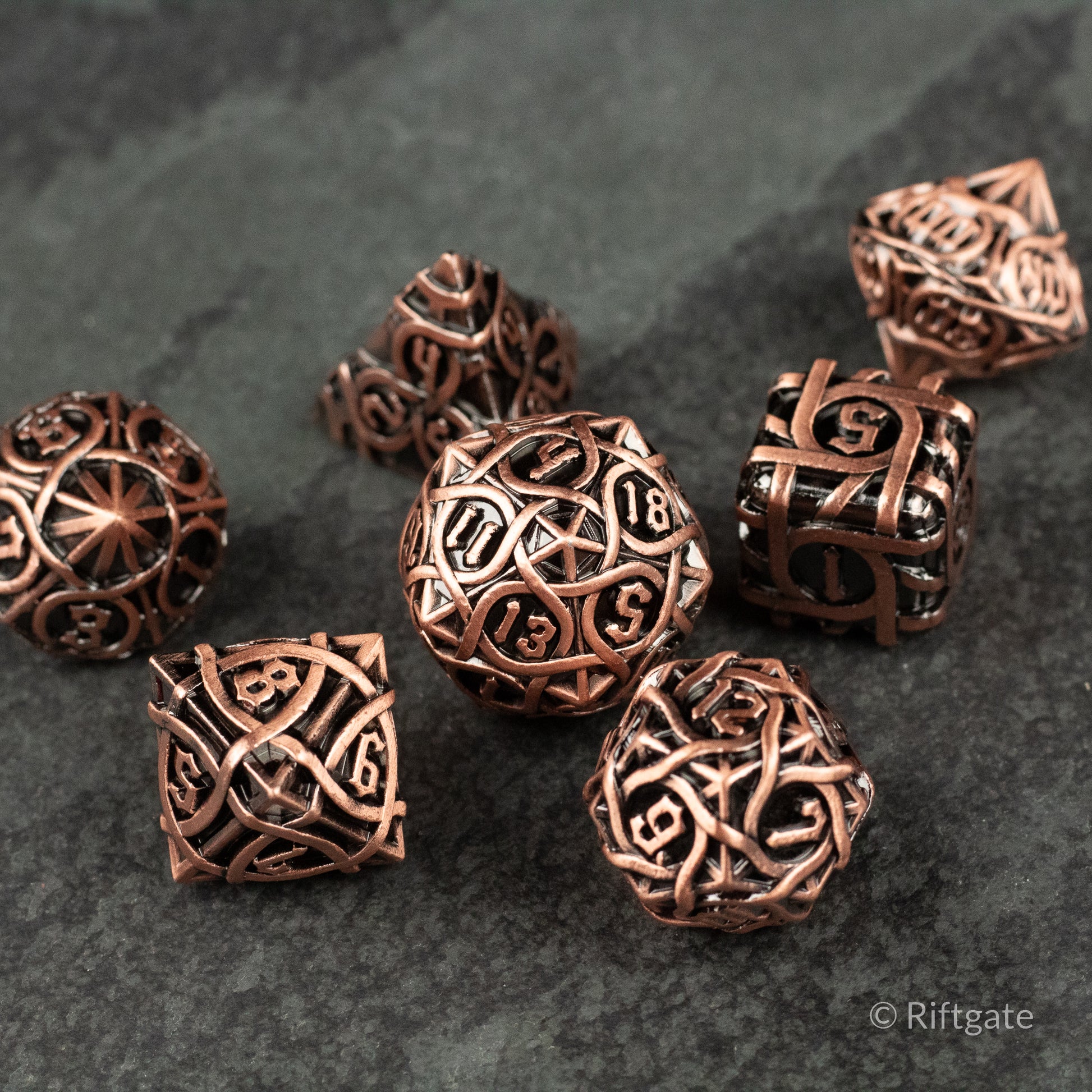 Runeweave Metal Dice Set - Copper-colored metal dice set with intricate rune-like engravings on multiple polyhedral shapes.