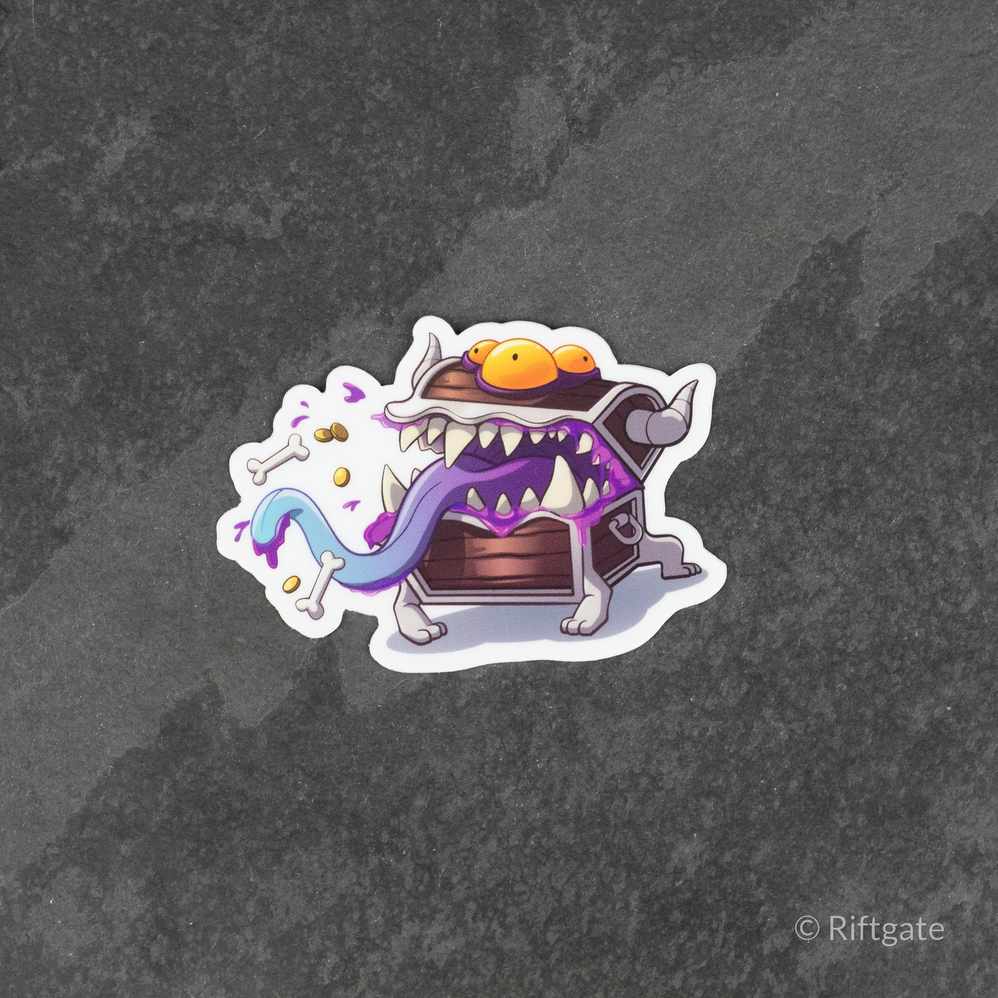 Mimic DnD Sticker - Purple mimic chest with sharp teeth and a long tongue, cartoon-style sticker with fantasy elements.