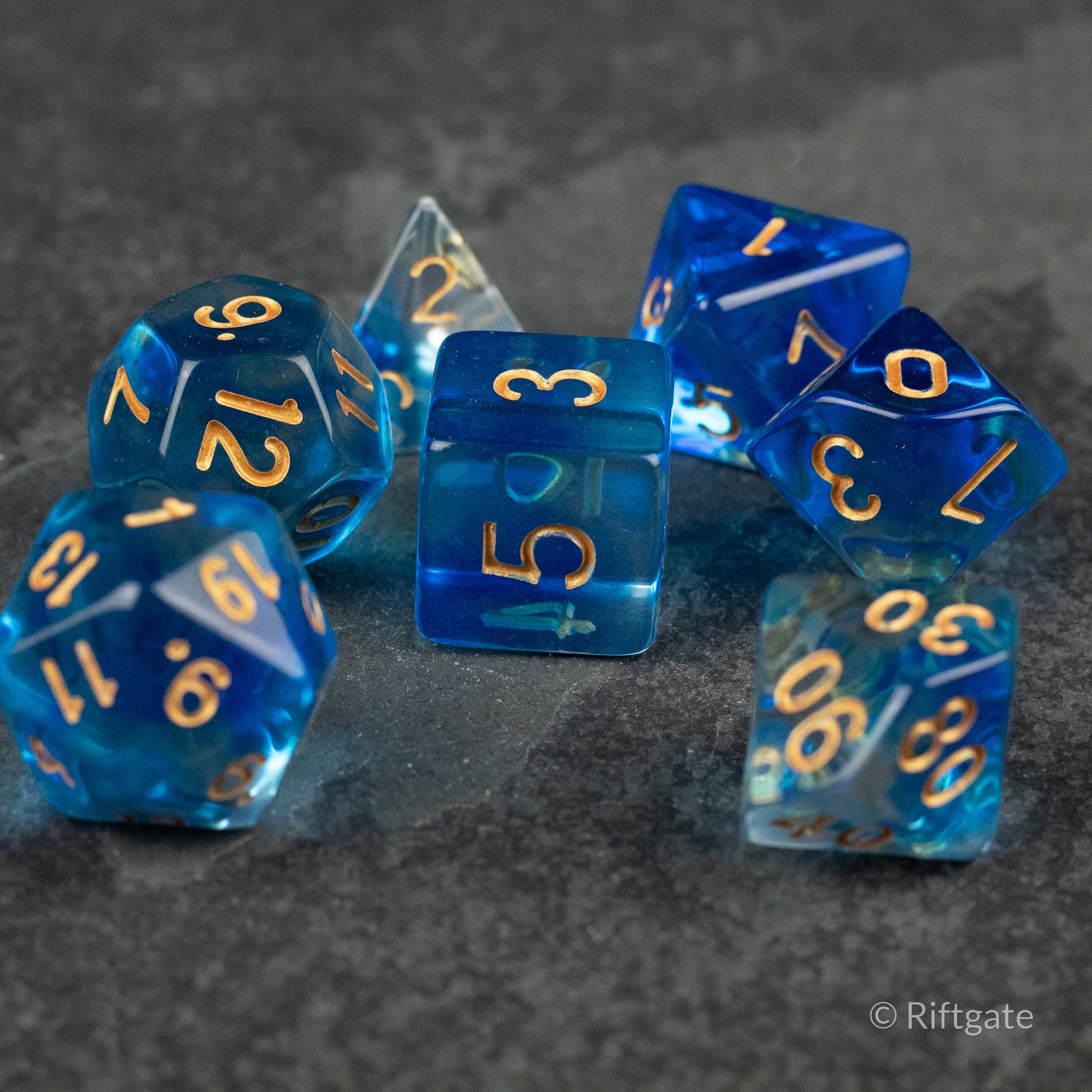 Ethereal Mist Dice Set - Transparent blue polyhedral dice set with gold numbers, including d20, d12, d10, d8, d6, and d4.