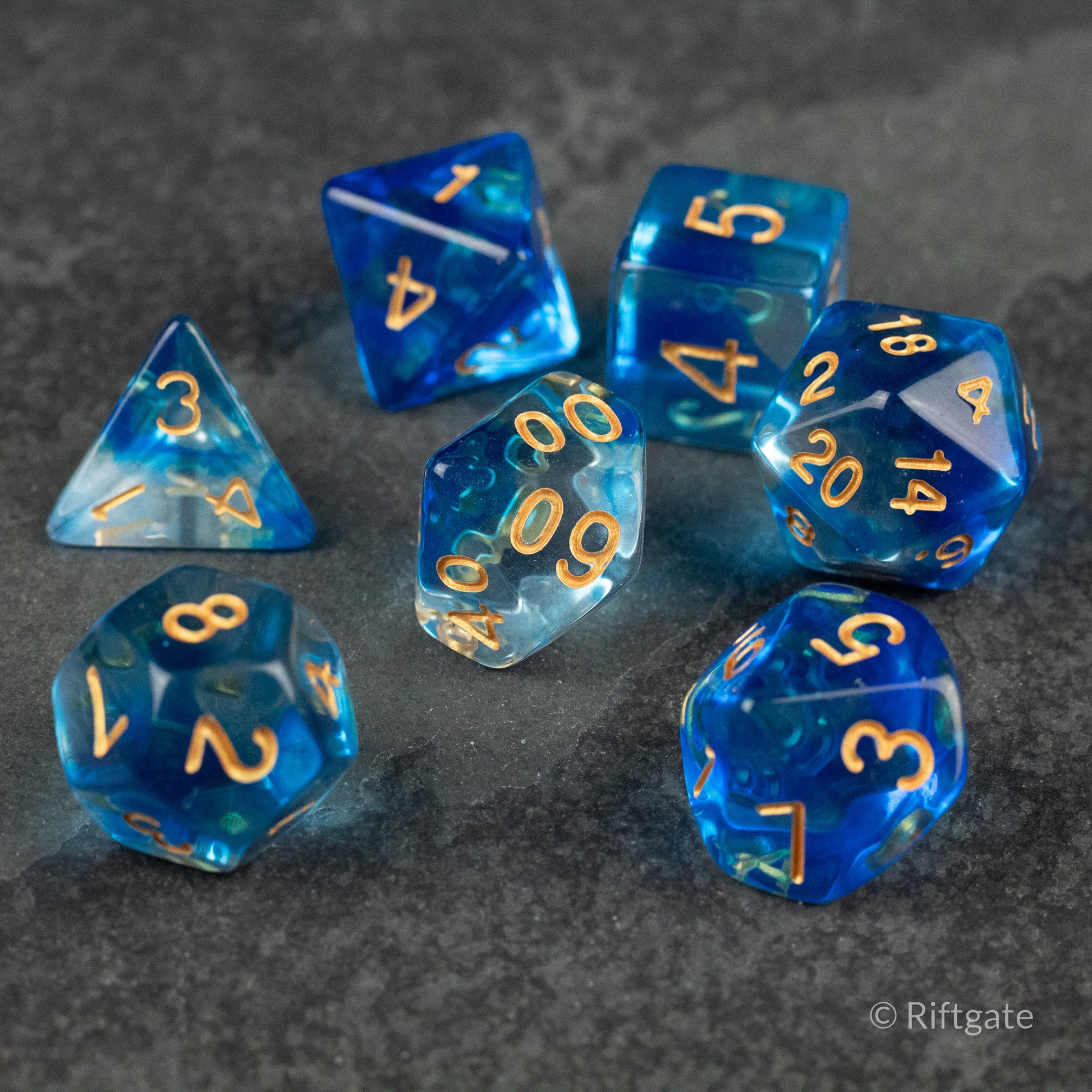 Ethereal Mist Dice Set - Translucent blue polyhedral dice set with gold numbers, including d4, d6, d8, d10, d12, and d20 shapes.