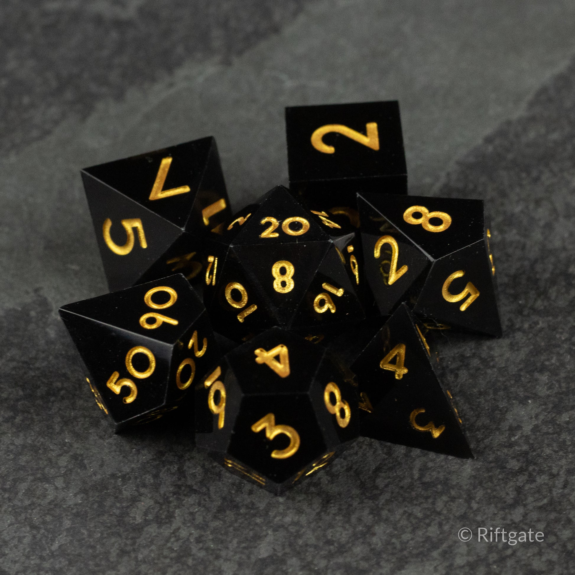 Midnight Sovereign Dice Set - Black sharp-edged polyhedral dice with gold numbering for tabletop games.