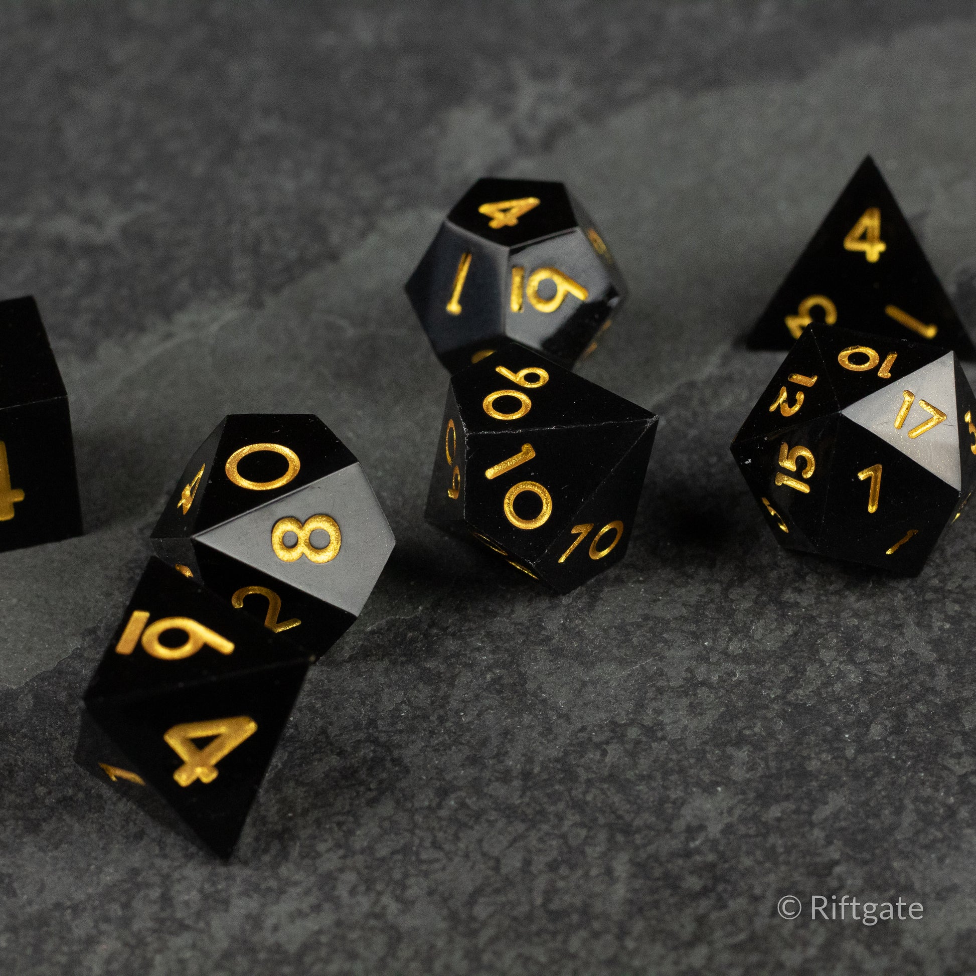 Midnight Sovereign Dice Set - Black polyhedral dice set with sharp edges and gold numbering on a dark textured surface.